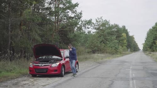 Man on Phone by Car with Open Hood