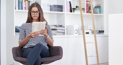 Woman Reading Book and Relaxing in Chair