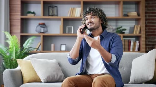 Man Relaxing on Sofa While Talking on Phone