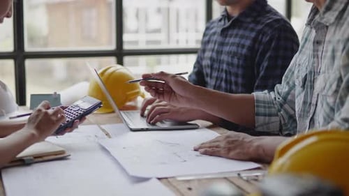Des personnes travaillant de près travaillent et réfléchissent à des documents concernant les affaires, les finances et le marketing.