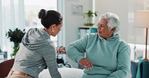 Physical Therapist Assessing Senior Woman's Arm Movement