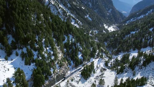 Cinematic Aerial Drone Shot Following Train in Snow Mountain Landscape