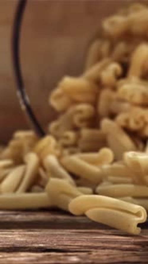 Dry Pasta Falls on a Wooden Table Filmed on a Highspeed Camera at 1000 Fps