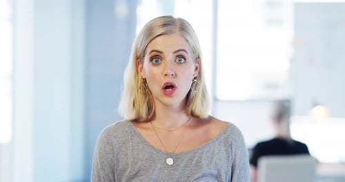4k video footage of an attractive young businesswoman looking shocked while standing in her office