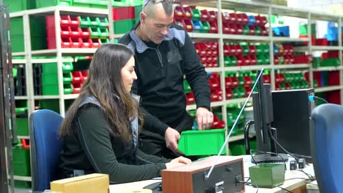Travailleurs utilisant un ordinateur pour faire l'inventaire dans un centre logistique