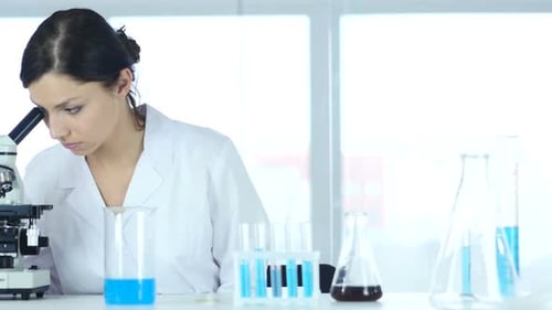 Chemist Scientific Reseacher Working on Microscope in Laboratory