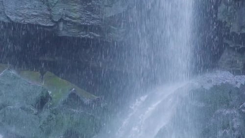 Wasserfall fällt in Zeitlupe auf die Felsen
