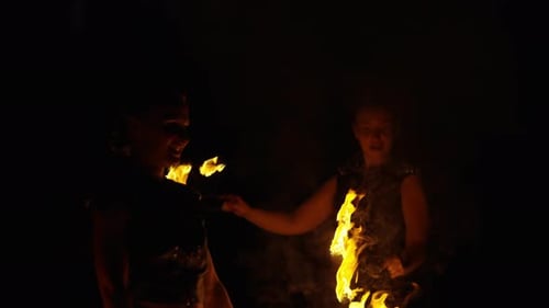 Fire Dancers Performing with Fiery Flames at Night