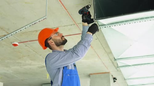Man Working on Ceiling Ventilation with Drill