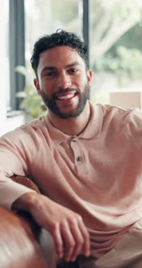 Man Smiling While Sitting on a Couch Inside