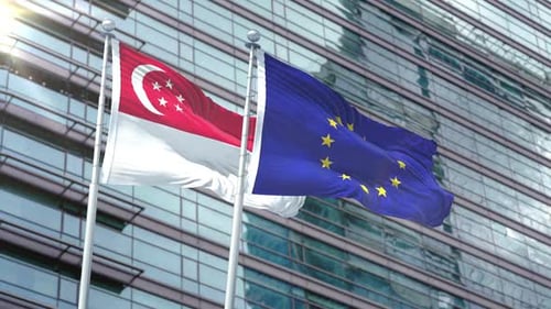 Waving Singapore and European Union Flags on Modern Corporate Building