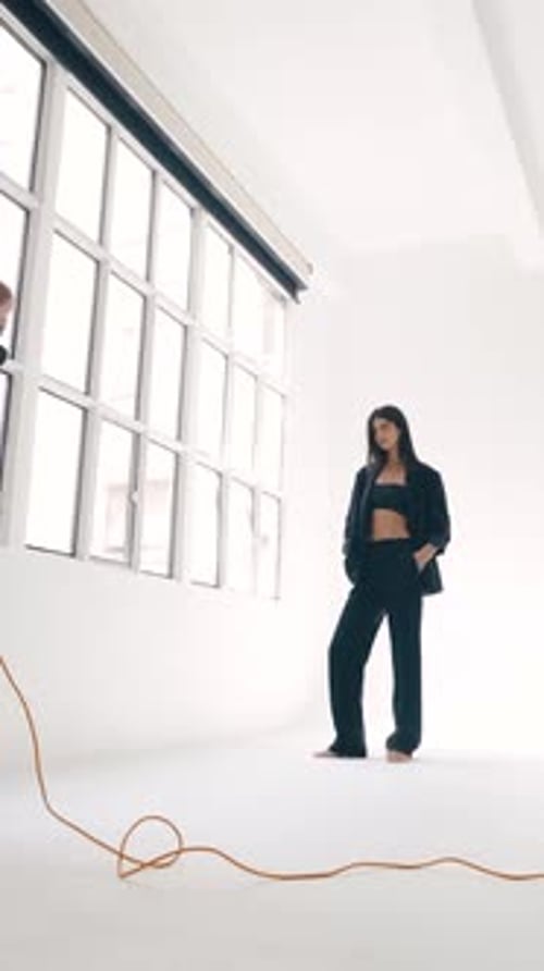 Professional Photoshoot Photographer Taking Pictures of a Model in a Studio Vertical