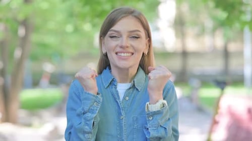 Young Woman Celebrating Success Outdoor in Park