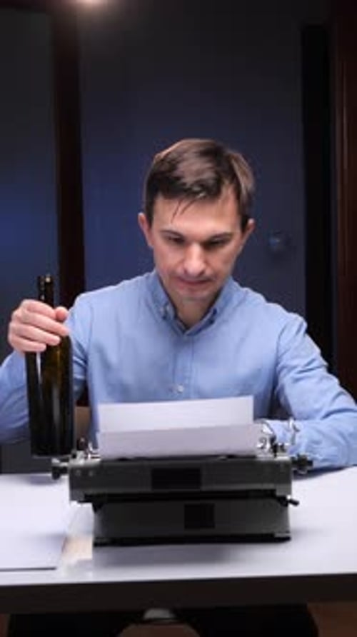 Vertical Video Man Drinking Alcohol Directly From a Bottle Experiencing Writer's Block While Sitting