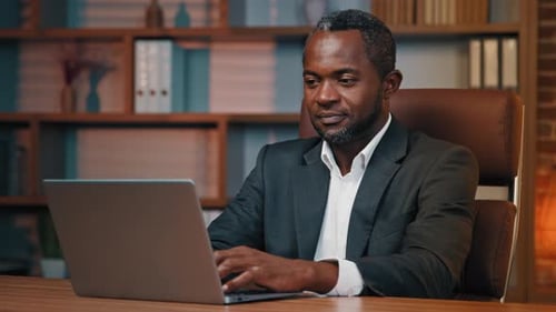 Focused African American Businessman Working in Office Typing on Laptop Using New Business Computer
