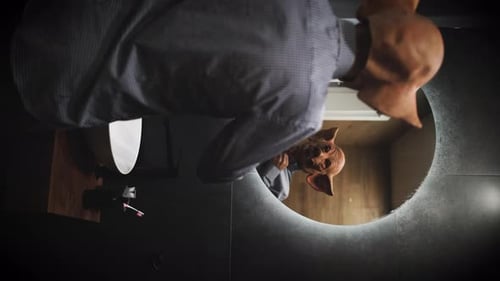 Man in Shirt with Creepy Pig Mask Looking in the Mirror