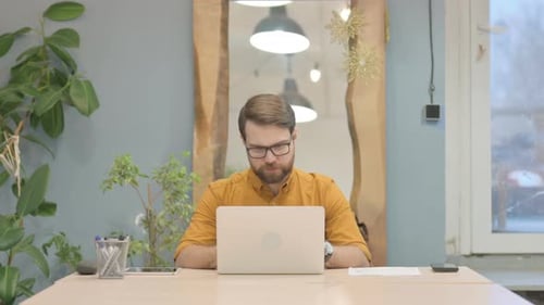 Young Businessman Reacting to Loss While Working in Office