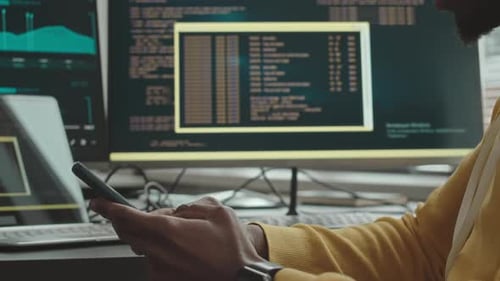 Black Man Using Smartphone at Programmer Office