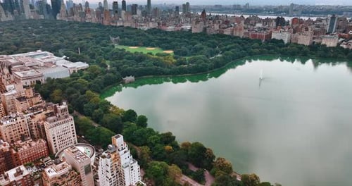 Beautiful view of Central Park in New York. Green zone with lake surrounded by building. Top view.