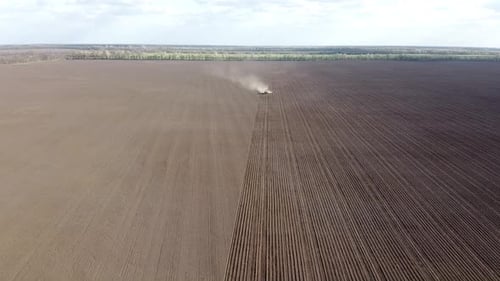 Tractor with yellow seeder working on the field in Ukraine OA Lexa