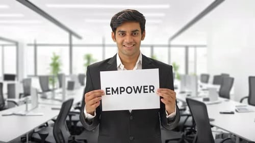 Young Professional Holds Empower Sign in Modern Office