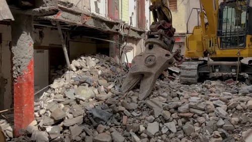 Excavator Demolishing Building in Urban Landscape
