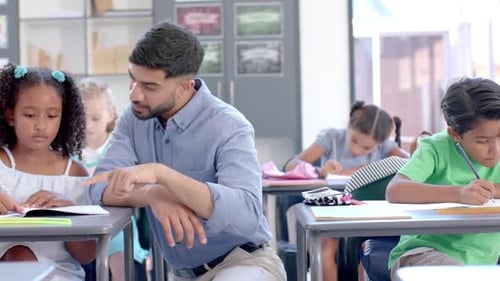 Young teacher assists a biracial girl in a classroom setting at school