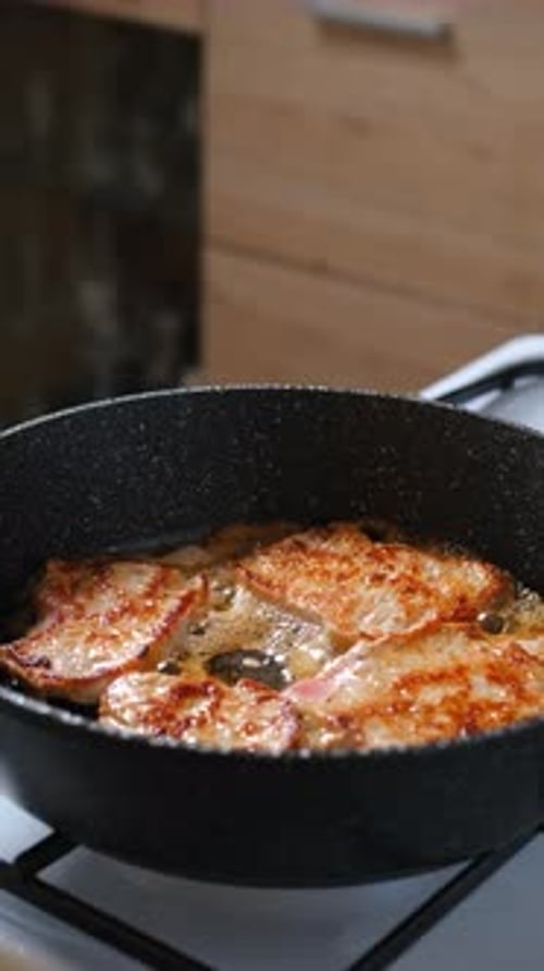 Pork Chops Are Sizzling In A Frying Pan