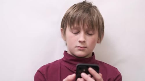 Distraught Child With Smartphone Indoors