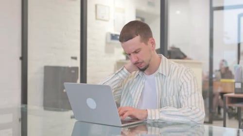 Young Adult Using Laptop Massages Sore Neck