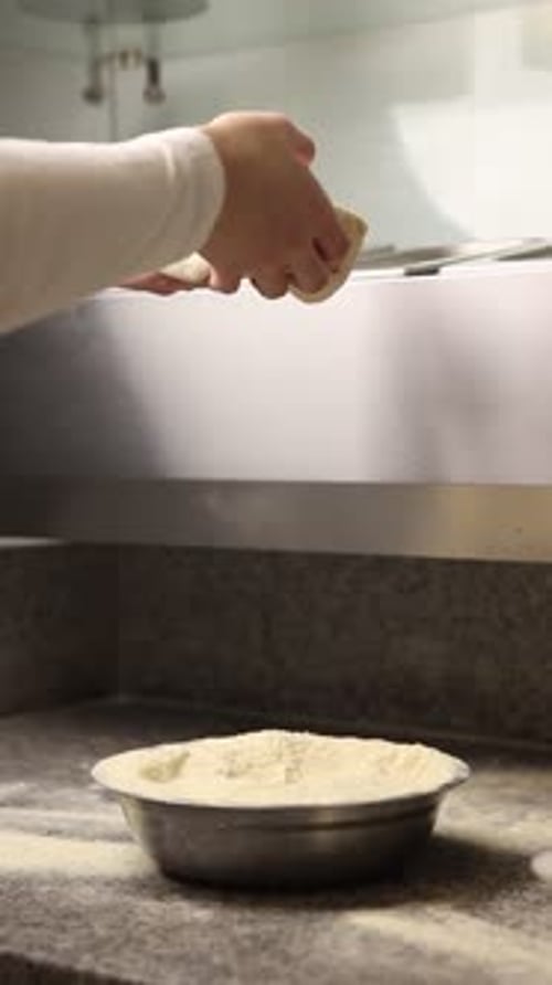 The chef makes delicious pizza in a professional kitchen.