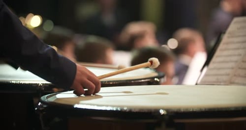 Schlagzeuger schlägt während einer Orchesteraufführung auf eine Konzerttrommel