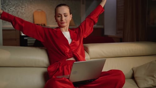 Woman Using Laptop Computer Stretching at Home
