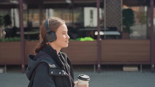 Contemplative Female Strolling Nearby Cafe with Coffee in Hand Calm Woman Leisurely Explores City