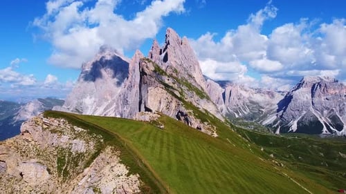 Vue aérienne en retrait depuis les sommets de Seceda avec des pâturages verdoyants et des sentiers de randonnée au premier plan