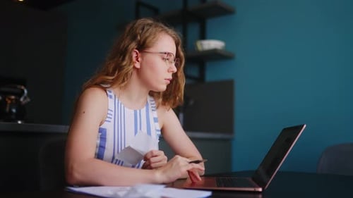 Woman Working with Laptop and Documents at Home