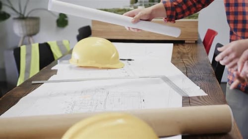 Collaborators Analyzing Architectural Plans in Modern Office