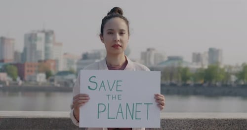 Woman Holds Save the Planet Sign in City