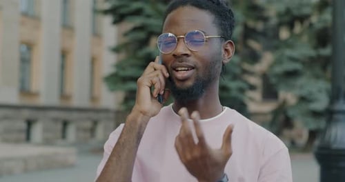 Portrait of African American Student Speaking on Mobile Phone Enjoying Conversation in City Street