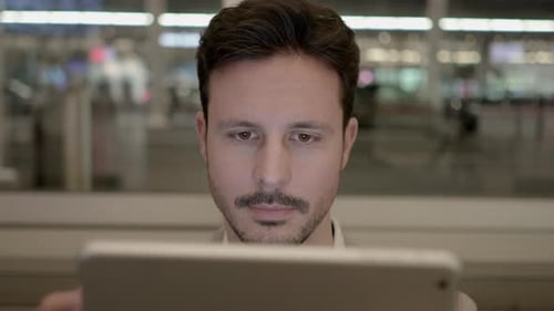 Portrait of Young Successful Man Using Tablet Screen on Business Travel Trip