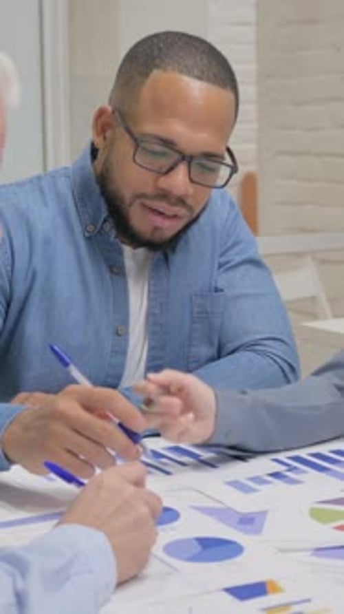 Business Team Reviews Data and Charts Together