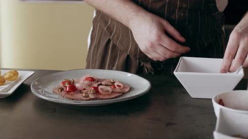 Chef Plating Beef Carpaccio Dish with Fresh Ingredients