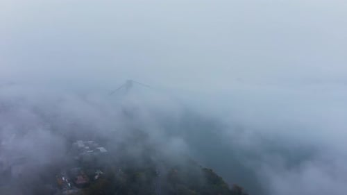 slow aerial descent through the clouds in New York City with the George Washington Bridge in the dis