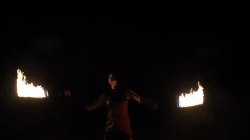 Woman Performing with Flaming Batons at Night