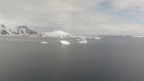 Icebergs flottant dans l'océan Arctique avec une énorme banquise à l'horizon, vue aérienne