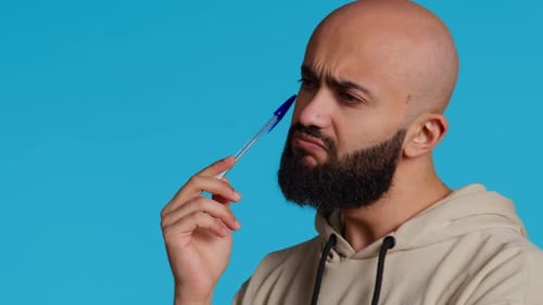 Man Thinking, Tapping Pen on Head in Studio