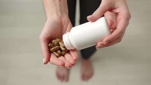 Natural Brown Pills in Hand From Above Focus on Health