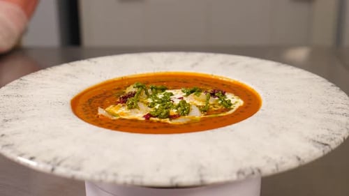 Bol de soupe aux tomates avec vue de dessus rotative sur le plat du restaurant servi sur une assiette blanche Présentation de