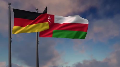 Germany and Oman National Flags Waving Against Blue Sky