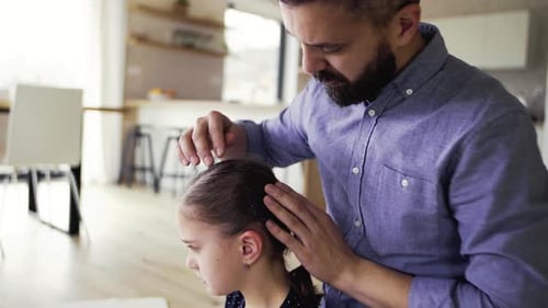 Loving Father Braiding Hair of Daughter in Home